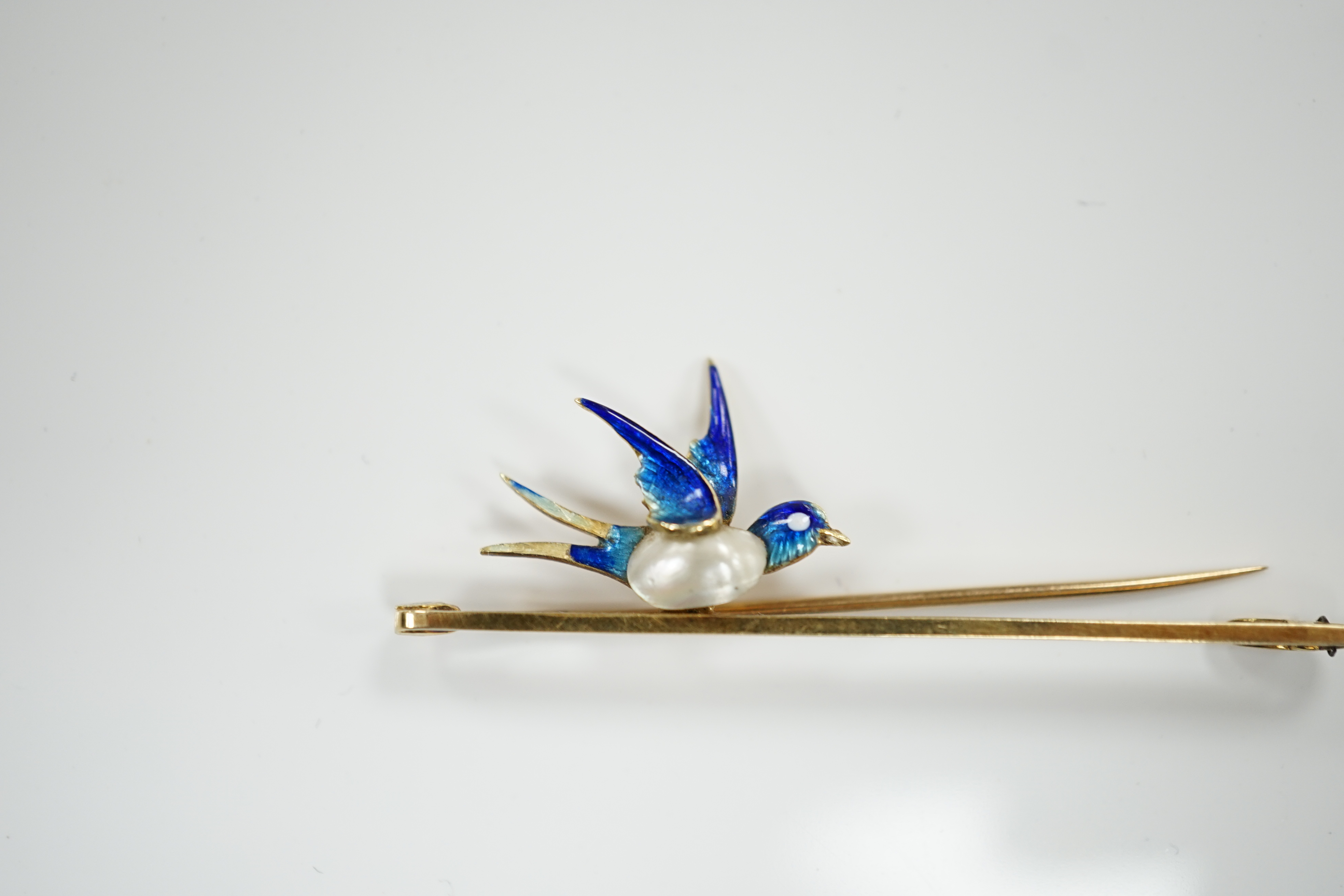 A yellow metal, baroque pearl and enamel bluebird bar brooch, 48mm, gross weight 3.1 grams.